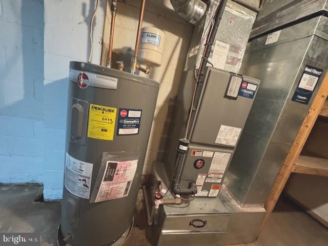 utility room featuring water heater and heating unit