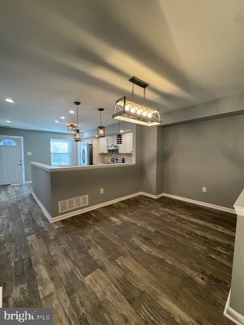 interior space featuring visible vents, recessed lighting, baseboards, and dark wood-type flooring