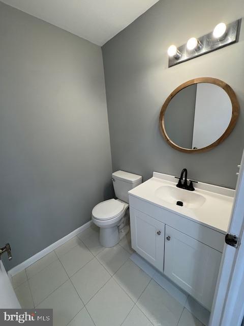 bathroom with vanity, tile patterned floors, baseboards, and toilet