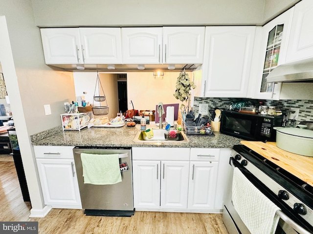 kitchen featuring glass insert cabinets, light wood-style floors, white cabinetry, a sink, and stainless steel appliances