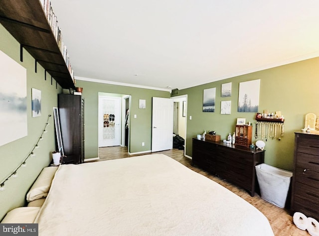 bedroom with crown molding and wood finished floors