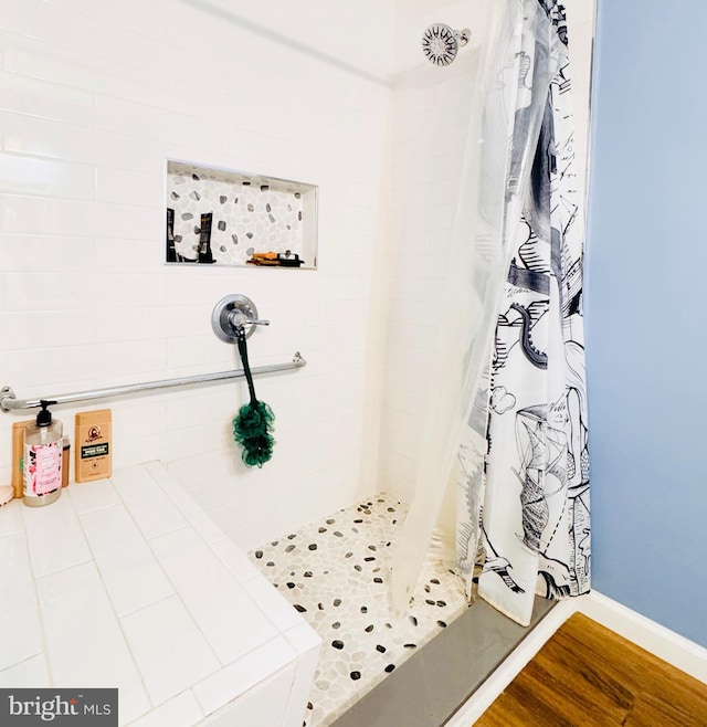 full bathroom featuring a stall shower and wood finished floors