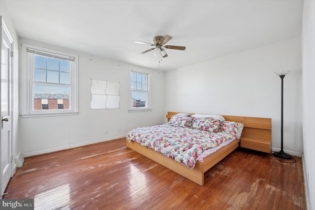 bedroom featuring a ceiling fan, baseboards, and hardwood / wood-style floors