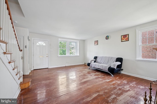 foyer entrance featuring wood-type flooring, baseboards, and stairway