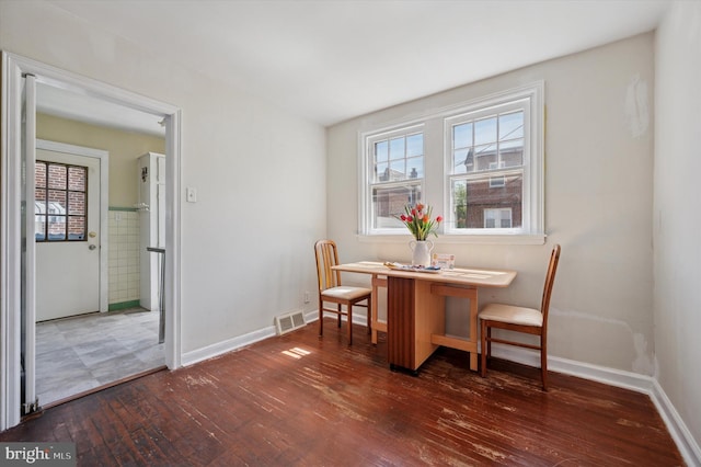 dining space with visible vents, baseboards, and hardwood / wood-style floors