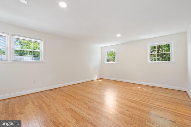 unfurnished room with baseboards, recessed lighting, and light wood-style floors