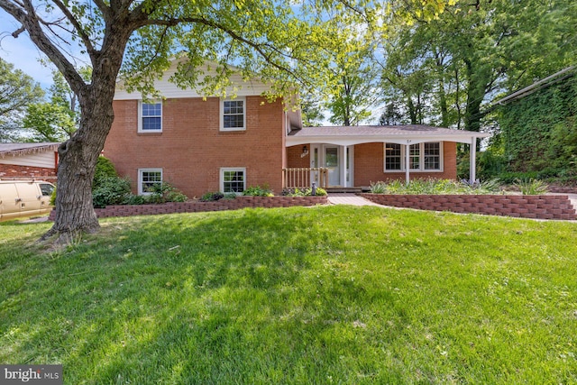 tri-level home featuring a front yard and brick siding