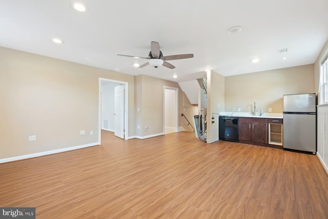 unfurnished living room featuring a ceiling fan, baseboards, recessed lighting, and light wood finished floors