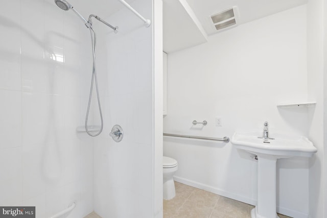full bathroom with visible vents, tile patterned flooring, baseboards, toilet, and tiled shower