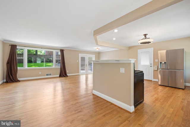 kitchen featuring stainless steel fridge, baseboards, crown molding, and visible vents