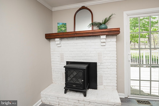 room details featuring baseboards, ornamental molding, a wood stove, and visible vents