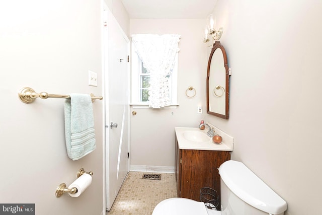 bathroom featuring vanity, baseboards, visible vents, and toilet