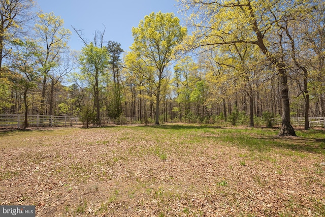view of yard featuring fence and a forest view