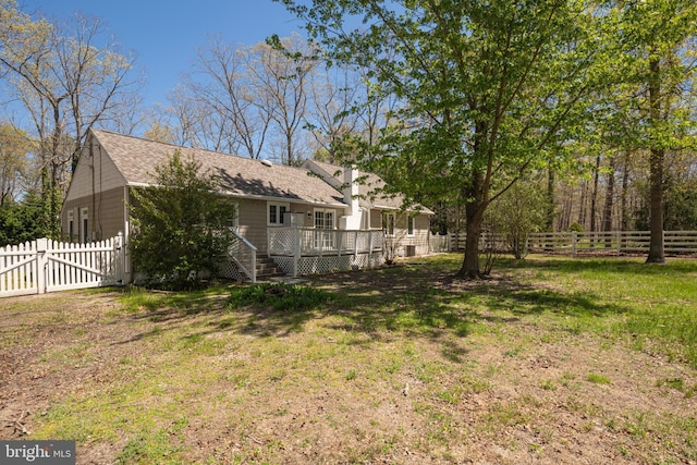 view of yard featuring a gate, a wooden deck, and a fenced backyard