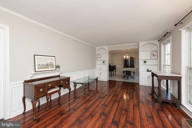 interior space featuring an inviting chandelier, dark wood finished floors, built in features, and a healthy amount of sunlight