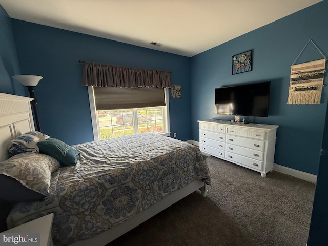 bedroom with baseboards, visible vents, and dark colored carpet