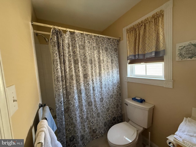 full bathroom with toilet and a shower with shower curtain
