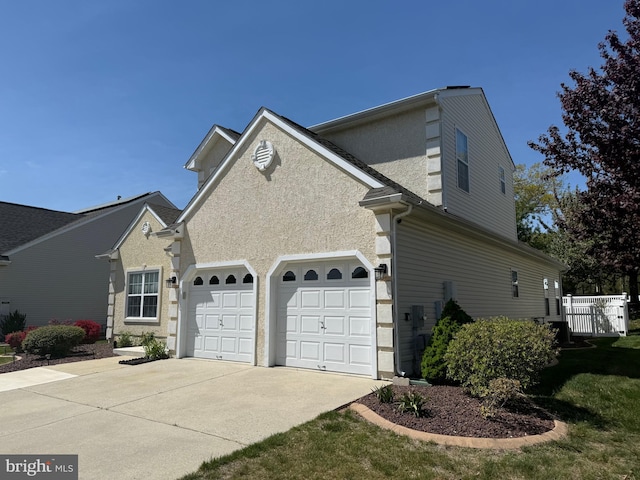 view of property exterior with a garage, stucco siding, and driveway