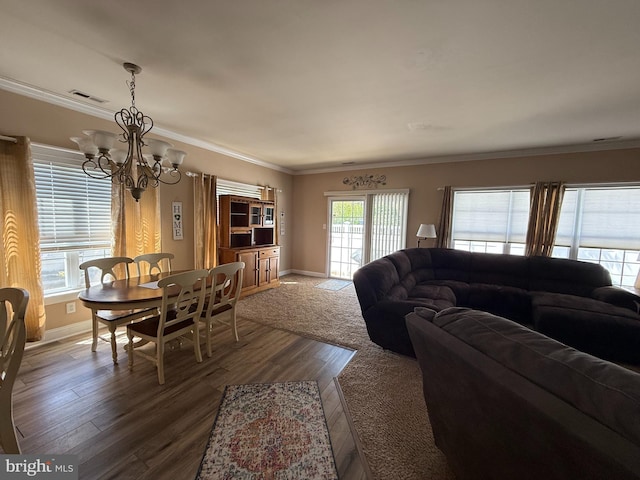 living room with visible vents, baseboards, wood finished floors, and a notable chandelier