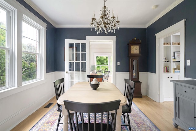 883 Locust Ave, Charlottesville, VA 22902 - dining area with a notable chandelier, visible vents, light wood-style flooring, and a wainscoted wall