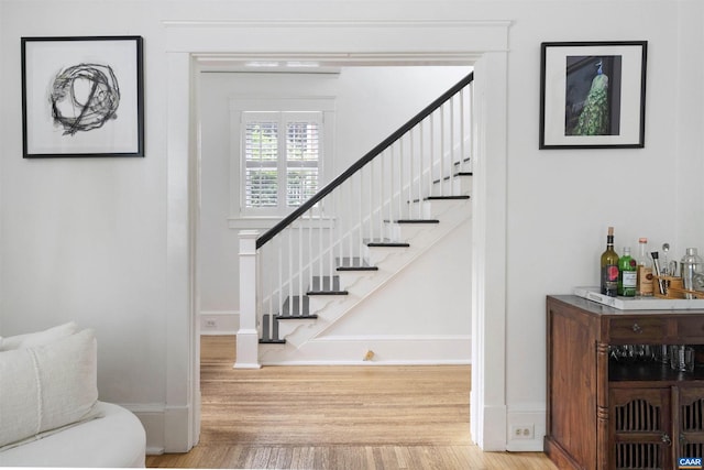 883 Locust Ave, Charlottesville, VA 22902 - stairway with baseboards, wood finished floors, and a bar