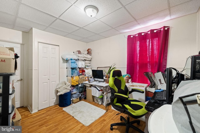 home office with a drop ceiling and wood finished floors