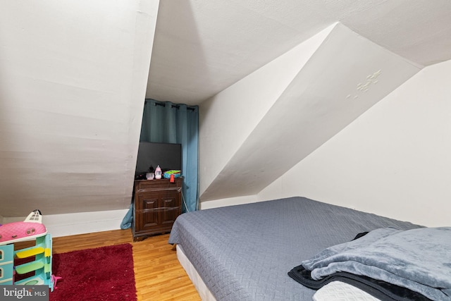 bedroom featuring vaulted ceiling and wood finished floors