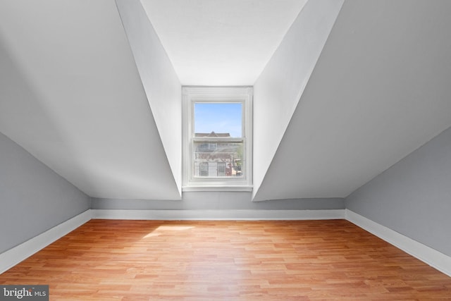 additional living space with baseboards and light wood-style flooring