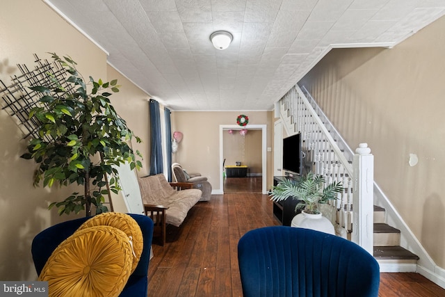 interior space featuring wood-type flooring, ornamental molding, baseboards, and stairway