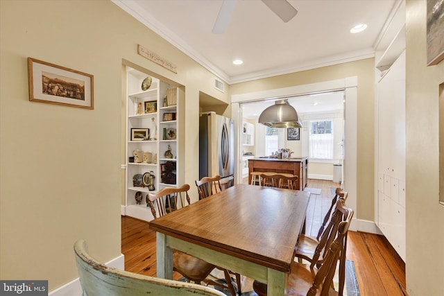 dining room featuring crown molding, visible vents, and light wood-style floors