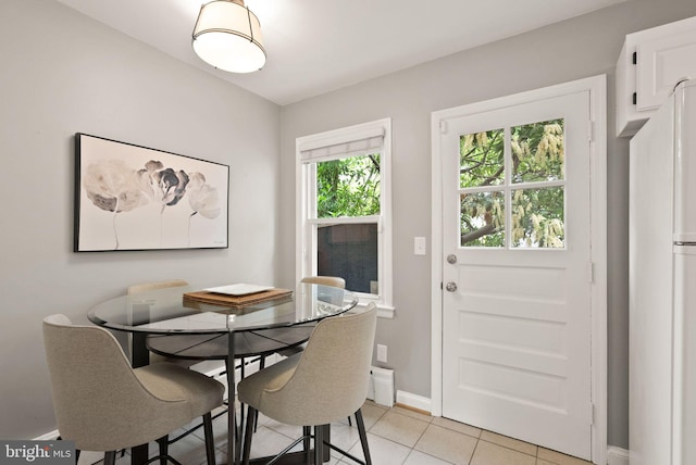 dining area featuring light tile patterned floors and baseboards