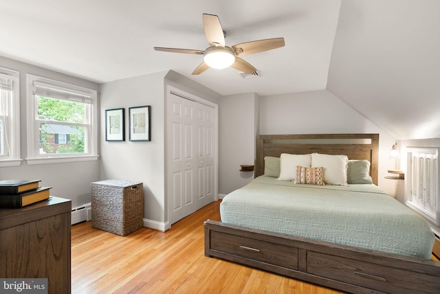 bedroom featuring light wood-type flooring, a closet, a baseboard radiator, a ceiling fan, and baseboards