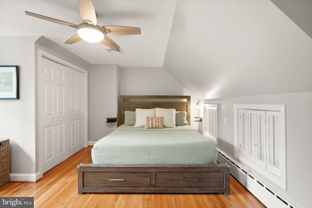 bedroom featuring baseboard heating, baseboards, lofted ceiling, wood finished floors, and ceiling fan