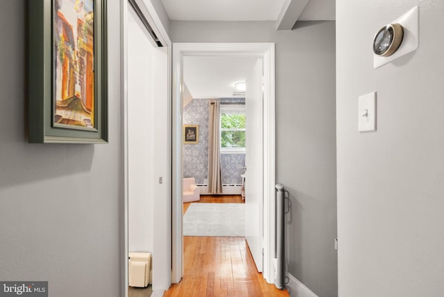 hallway with light wood-style flooring and baseboards