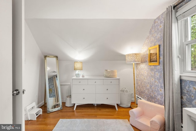 living area featuring wallpapered walls, light wood-type flooring, and baseboards