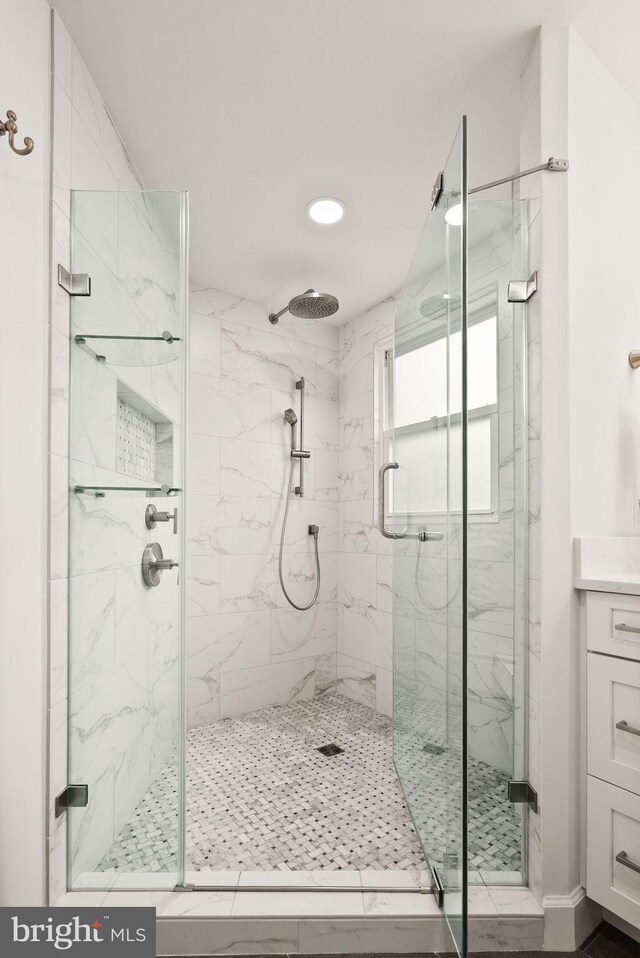 full bathroom with a marble finish shower, vanity, and recessed lighting