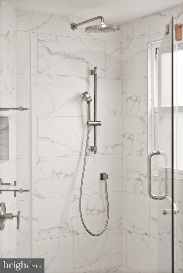 full bathroom featuring a marble finish shower