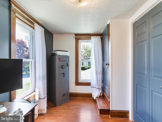 interior space with baseboards, wood finished floors, and an ornate ceiling