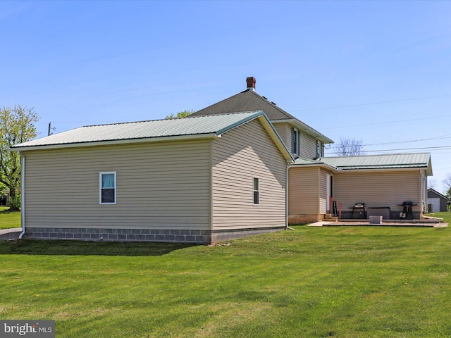 view of home's exterior with a lawn and metal roof