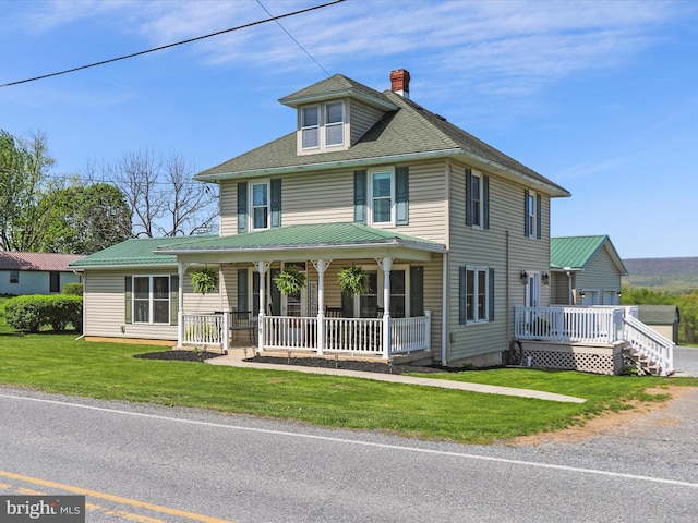 view of front of home featuring a front lawn, covered porch, and a chimney
