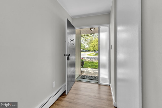 entryway featuring wood finished floors, baseboard heating, and baseboards
