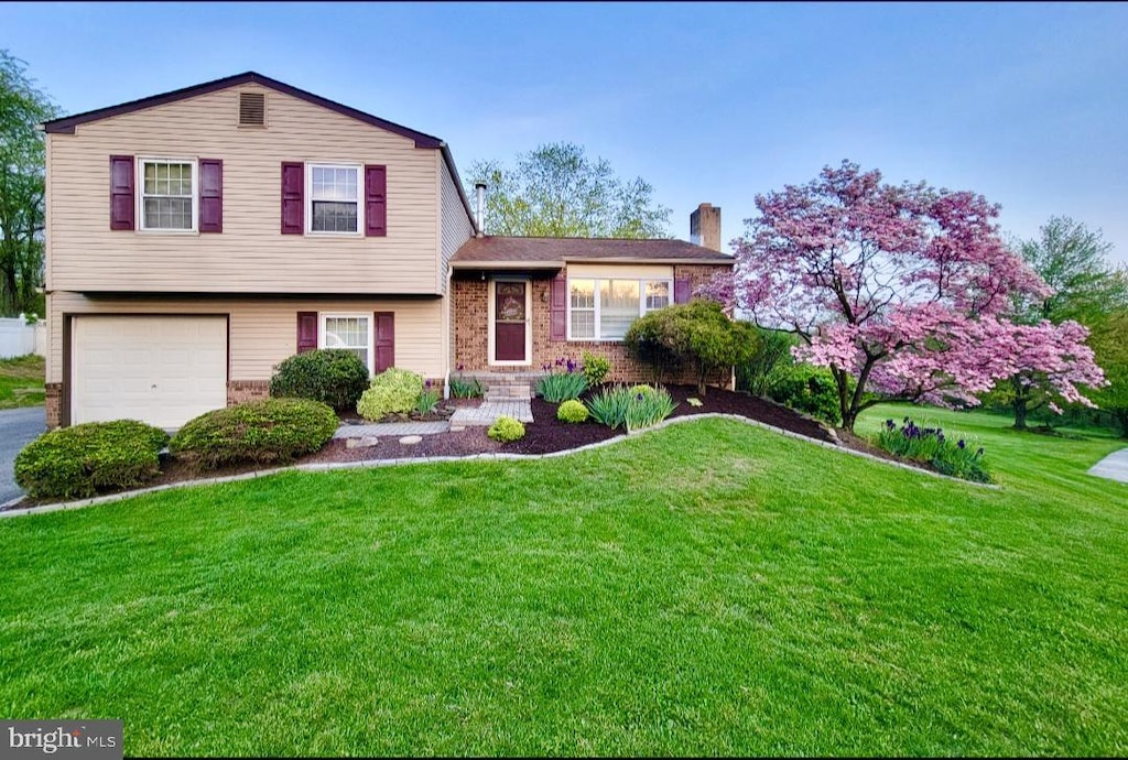 602 Oriole Ct, Harrisburg, PA 17111 - tri-level home with a garage, a chimney, a front lawn, and brick siding
