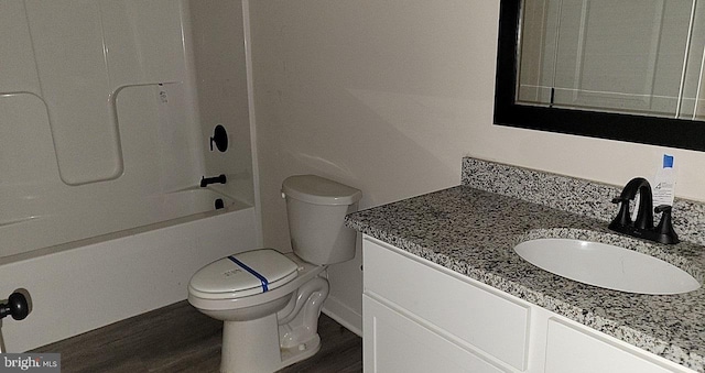full bath featuring vanity, tub / shower combination, wood finished floors, and toilet