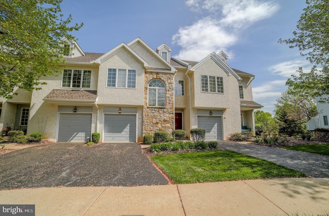 view of front of home featuring a front lawn, stone siding, a garage, stucco siding, and driveway