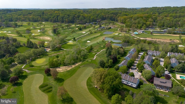 bird's eye view with a water view, a view of trees, and view of golf course