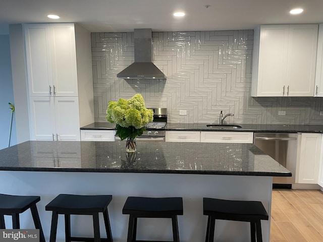 kitchen featuring a sink, white cabinets, appliances with stainless steel finishes, and exhaust hood