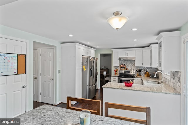 202 Trail Ct, Sterling, VA 20164 - kitchen featuring appliances with stainless steel finishes, a sink, under cabinet range hood, dark wood-type flooring, and white cabinetry