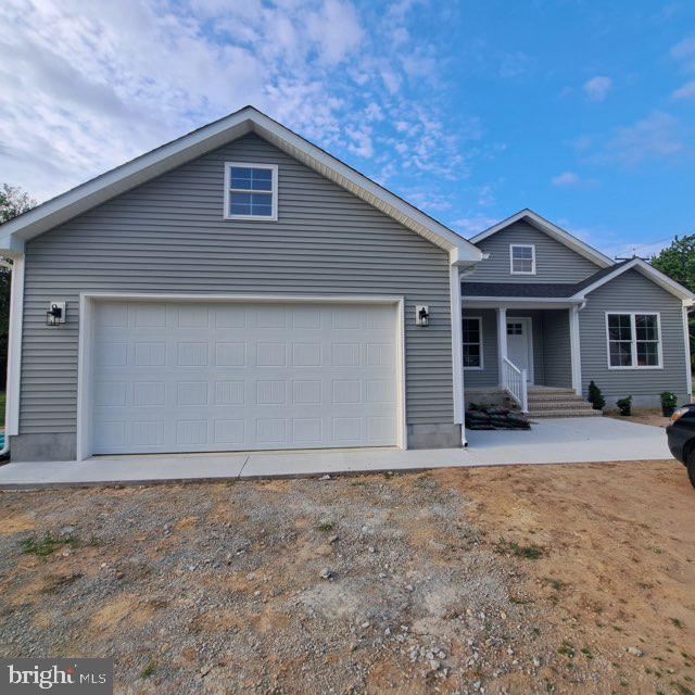 101 Thompson St, Hurlock, MD 21643 - view of front of property with a porch, an attached garage, and driveway