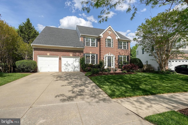 colonial home featuring brick siding, a front lawn, a garage, concrete driveway, and roof with shingles