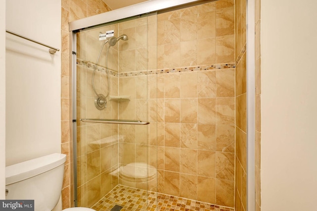 full bath featuring a stall shower and toilet
